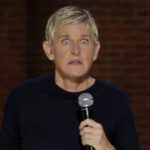 Ellen DeGeneres speaking on stage while holding a microphone