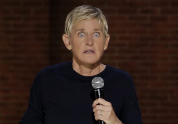 Ellen DeGeneres speaking on stage while holding a microphone
