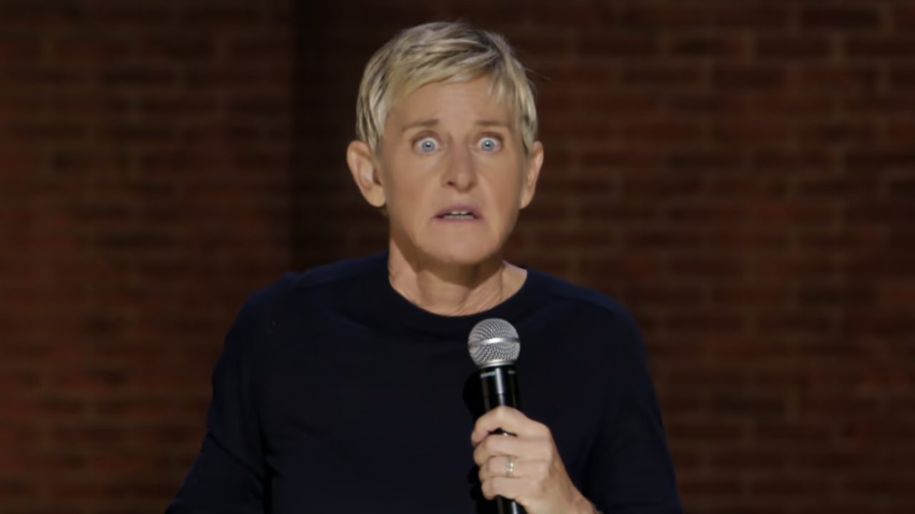 Ellen DeGeneres speaking on stage while holding a microphone