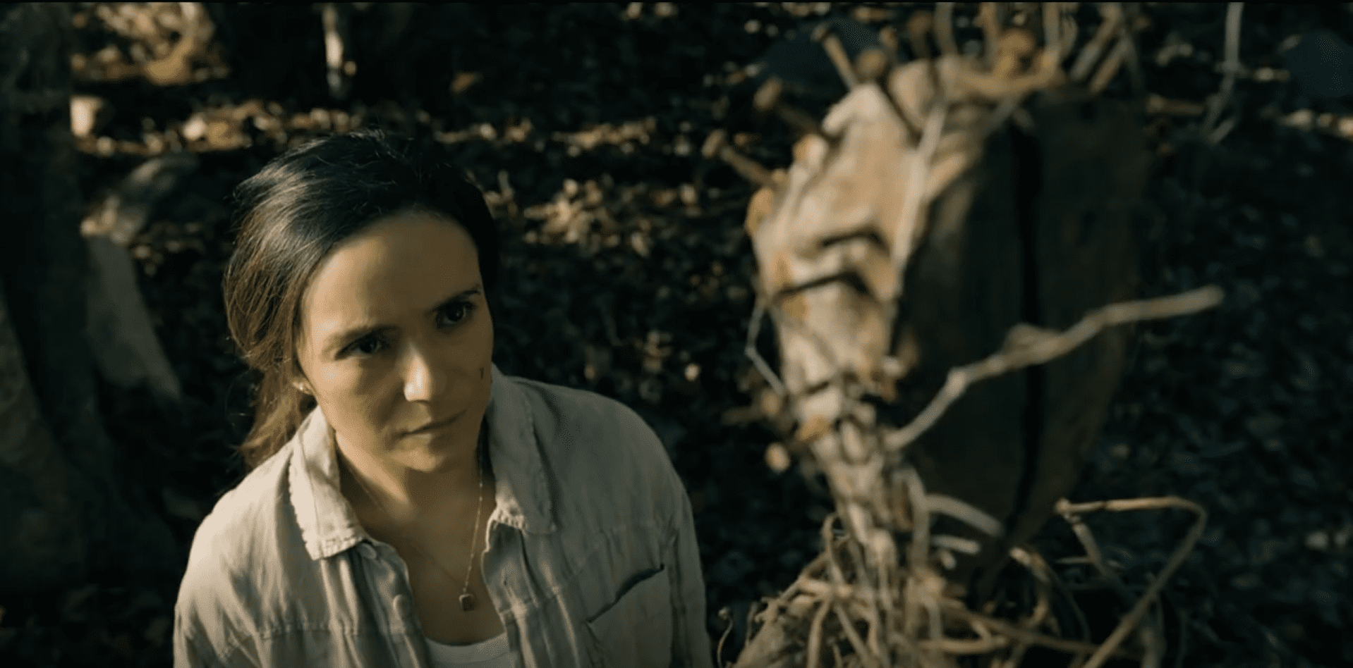 Tabitha looks up at a totem in the forest in FROM Season 4 Episode 5