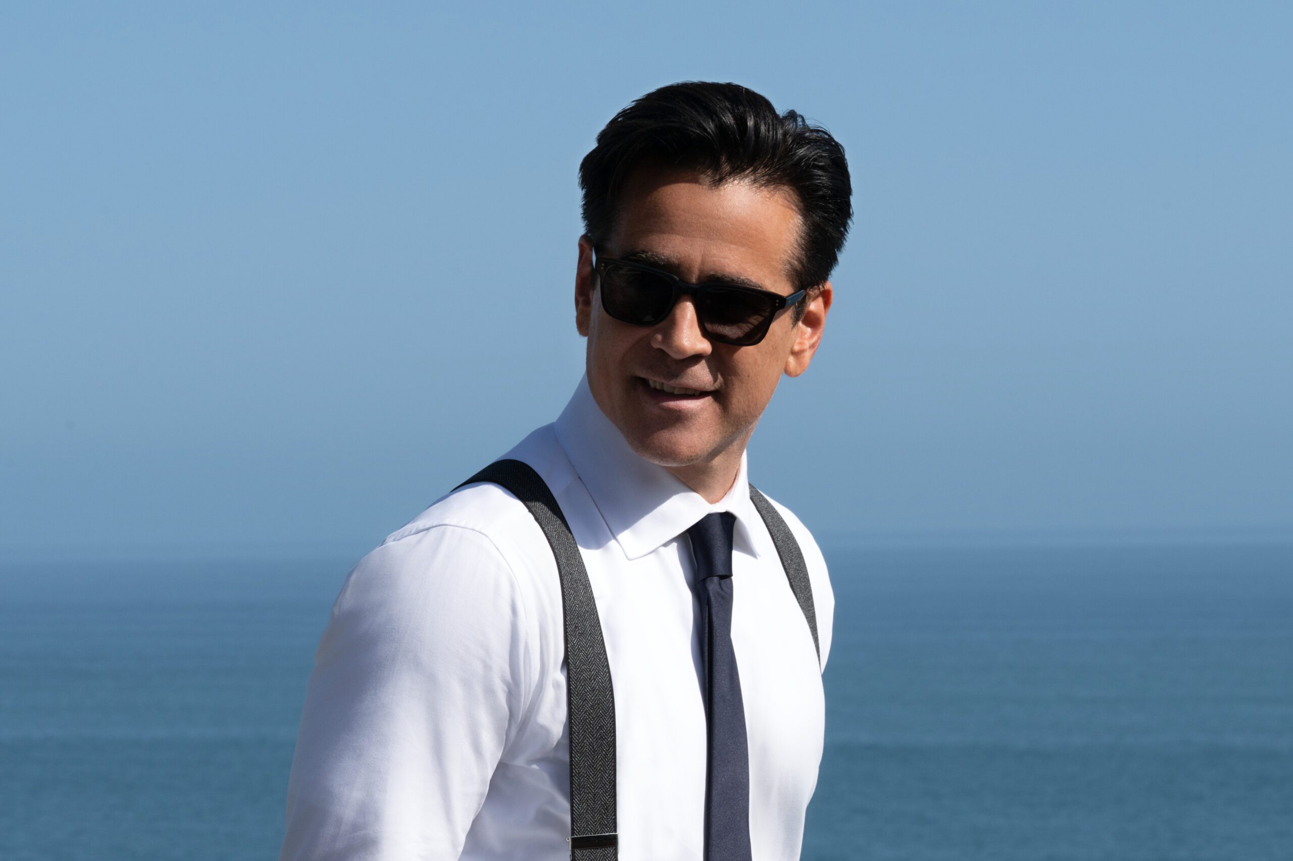Sugar Season 2 promotional image showing a detective in sunglasses standing near the ocean.