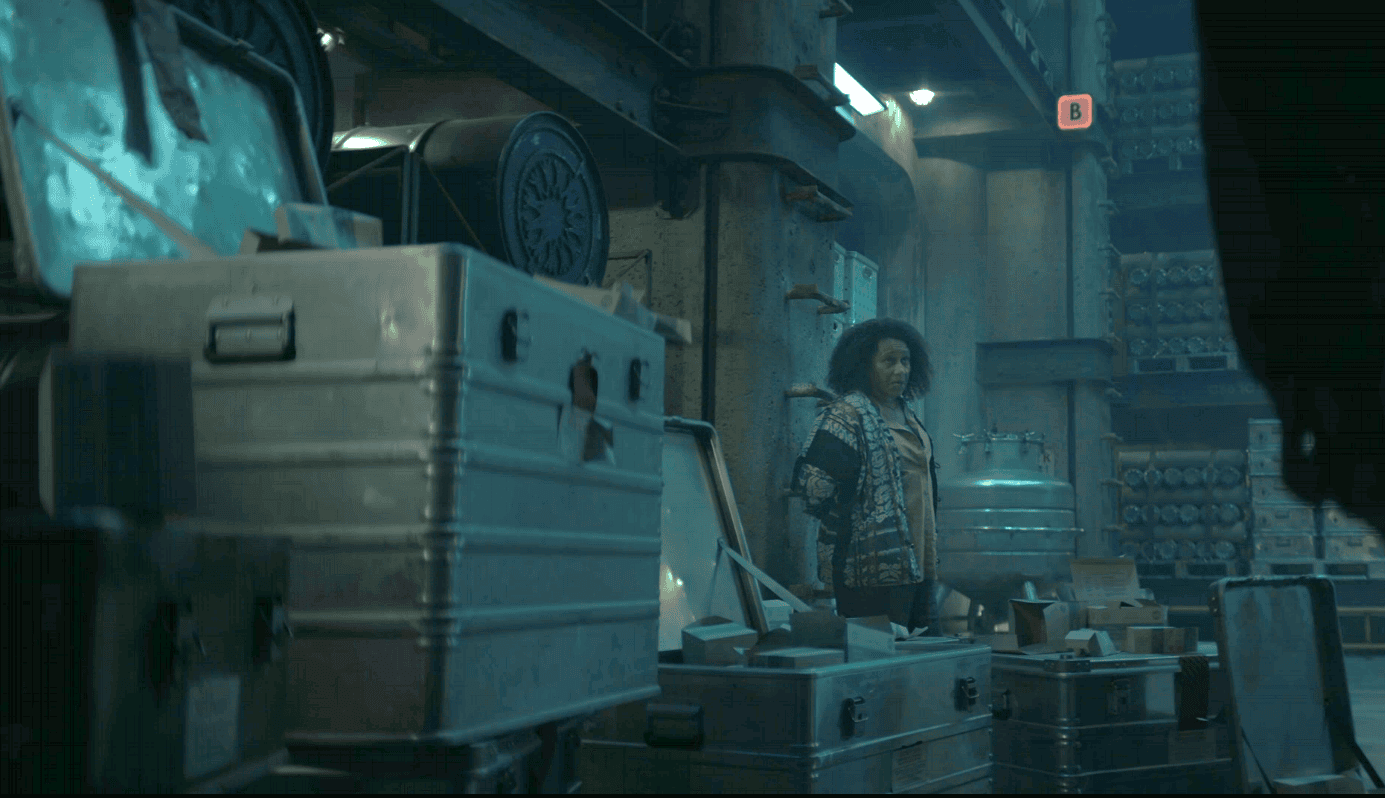 Carla standing among empty storage cases in Critical Supply in Silo Season 3 Episode 5.