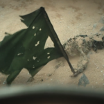 Body beside a torn green flag outside Silo 17 in Silo Season 3