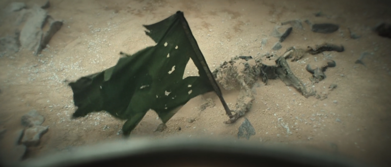 Body beside a torn green flag outside Silo 17 in Silo Season 3