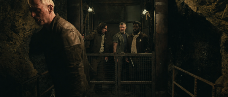 Harwood walks away as Billings and the others discover his hidden elevator beneath the Mines in Silo Season 3.