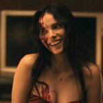 Inde Navarrette as Nikki smiling with blood on her face in Obsession