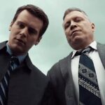 Two FBI agents from Netflix’s Mindhunter look down toward the camera in a scene from the crime drama series.