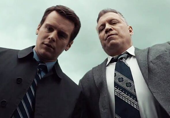 Two FBI agents from Netflix’s Mindhunter look down toward the camera in a scene from the crime drama series.